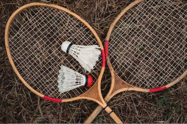 Wooden badminton rackets and a white feather shuttlecock and a plastic one with a red head. The game of badminton. Hobbies and outdoor recreation. Seth badminton for two. - Photo, Image
