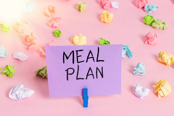 Handwriting text writing Meal Plan. Concept meaning act of taking time to plan any number of meals for the week Colored crumpled papers empty reminder pink floor background clothespin. - Photo, Image