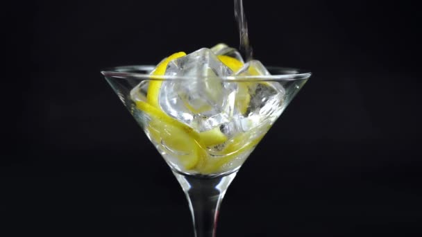 Αφρώδες νερό με λεμόνι και πάγο, λευκή σόδα σε ποτήρι σε μαύρο φόντο, δροσιστικό κρύο ποτό - Πλάνα, βίντεο