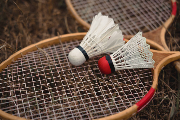 Wooden badminton rackets and a white feather shuttlecock and a plastic one with a red head. The game of badminton. Hobbies and outdoor recreation. Seth badminton for two. - Photo, Image