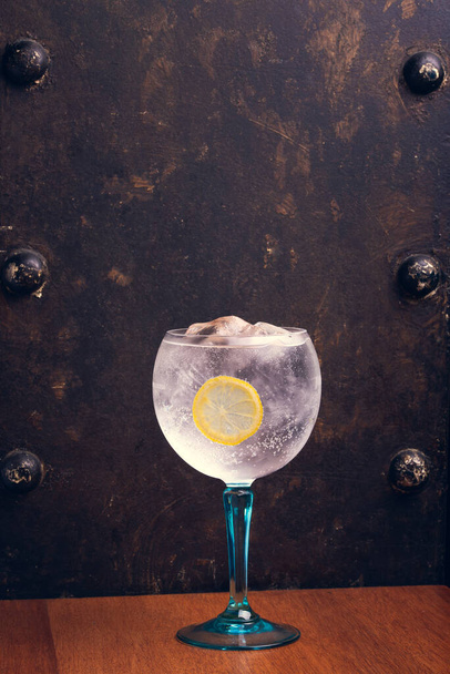 Gin Tonic auf rustikalem Hintergrund mit Platz für Text. Vertikaler Schuss. - Foto, Bild