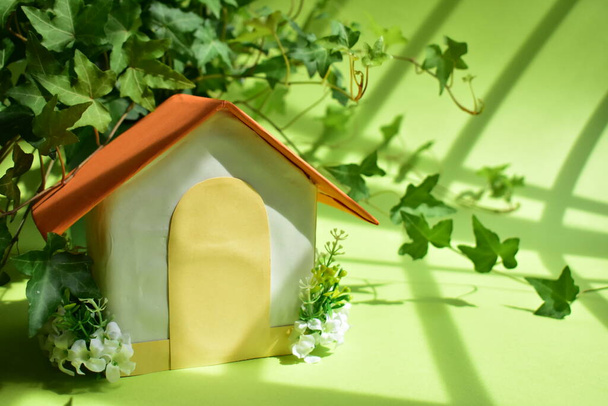 Ecológico, casa de papel en fondo verde, hojas de hiedra (Hedera Helix) hojas de primavera, concepto de inversión, abstracto de bienes raíces, verde pastel, hogar dulce hogar, nueva casa, hogar de amor, soleado
 - Foto, imagen