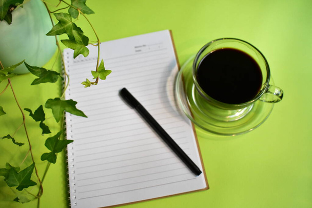 Зелене робоче місце, зелений офісний стіл з чорною чашкою кави, пастельний зелений фон, свіже, нове життя, мир, екологічно чисте
 - Фото, зображення