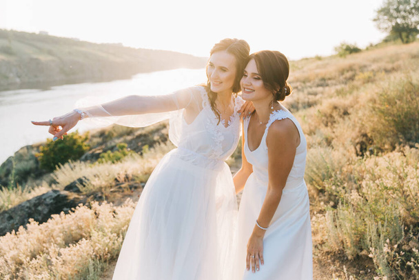 Pareja de boda lesbiana en vestidos blancos
 - Foto, Imagen