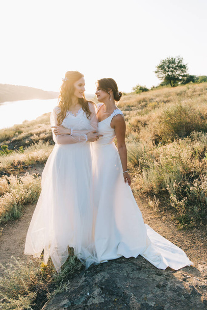 Pareja de boda lesbiana en vestidos blancos
 - Foto, Imagen