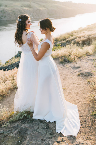 Pareja de boda lesbiana en vestidos blancos
 - Foto, imagen