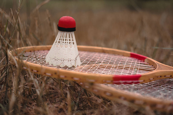Wooden badminton rackets and a white plastic shuttlecock with a red head. The game of badminton. Hobbies and outdoor recreation. Set of badminton for two. - Fotó, kép