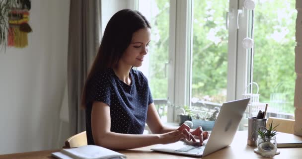 Woman accomplish work on laptop puts hands behind head relaxing - Кадри, відео