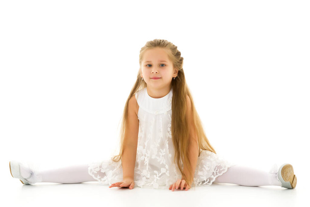 Little girl schoolgirl, performs gymnastic twine. - Фото, зображення