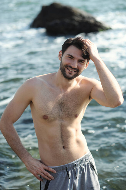 Young stylish man portrait near the sea, topless - Fotó, kép