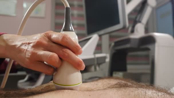 腹部音波検査の手順。超音波検査を受ける男性患者のクローズアップショット.医療の概念。医師の手による超音波検査です。4 kビデオ - 映像、動画