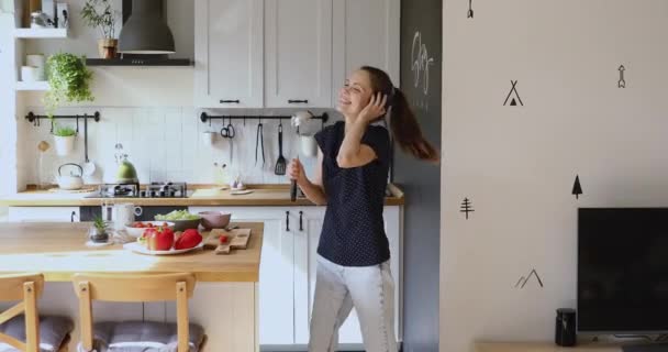 Woman wear headphones holding ladle like microphone dance sing song - Filmmaterial, Video