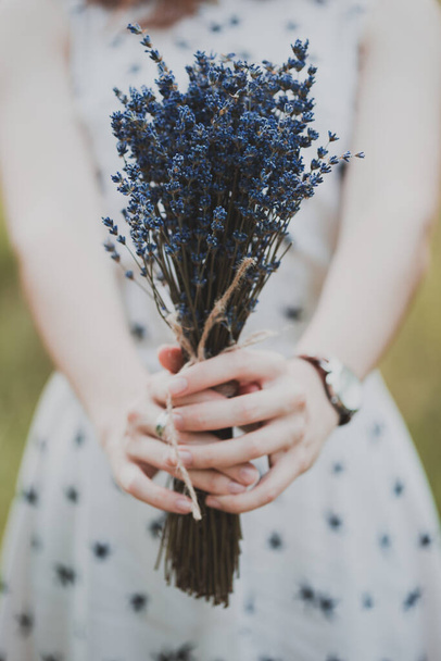 Summer - girl on a picnic in a meadow in the forest. lavender in the hand - Foto, afbeelding