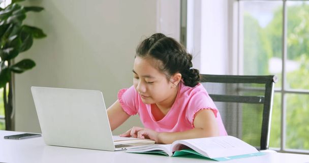 自宅で隔離されている間にオンライン距離学習を勉強している女の子. - 写真・画像