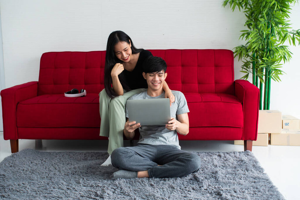 Glücklich asiatisch pärchen verbringen zeit zusammen auf sofa bei zuhause. - Foto, Bild
