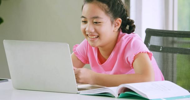 Una chica que estudia educación a distancia en línea mientras está en cuarentena en casa
. - Foto, Imagen