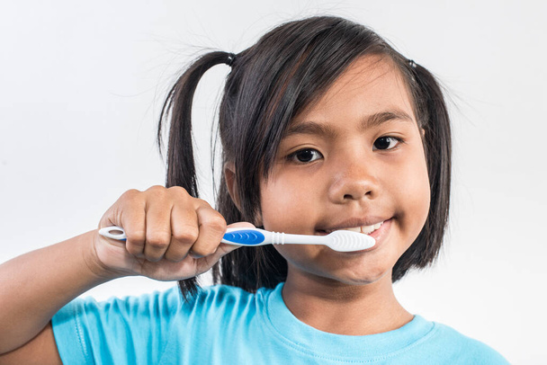 Pieni tyttö harjaamalla hampaitaan studio ammuttu - Valokuva, kuva