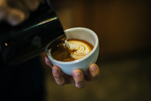 Close-up of hands barista make latte coffee art paint - Photo, Image