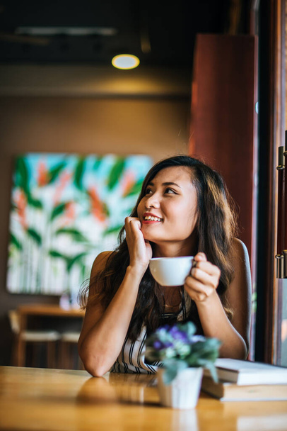 Портрет азиатская женщина улыбаясь расслабиться в кафе кафе
 - Фото, изображение