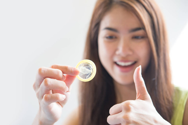 Junge Frau mit Kondom verhindert Schwangerschaft und sexuell übertragbare Krankheiten - Foto, Bild