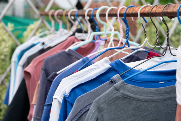 Großaufnahme von blauem Hemdbügel mit anderen Kleidungsstücken der Outdoor-Wäscheleine. - Foto, Bild