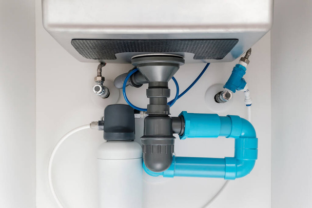 under sink plumbing and drainage system, water purification system install under modern kitchen sink, shallow depth of field - Photo, Image