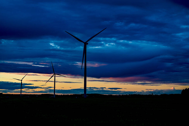 big windmills on field with dramatic sky - Photo, Image