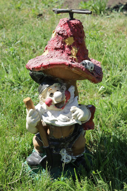 Device for watering a lawn in the form of a gnome with a shovel under the mushroom - Photo, Image