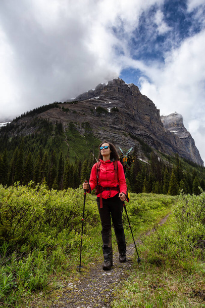 Female Backpacker Hiking in Canadian Rockies during a cloudy day. - Foto, Bild
