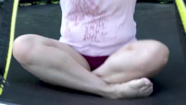 Толстая девушка неуклюже прыгает на батуте - Кадры, видео