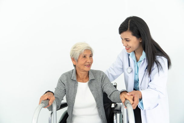 Физиотерапевт смотрит на старшего пациента, сидящего в инвалидном кресле, врача и пациента на инвалидной коляске
 - Фото, изображение