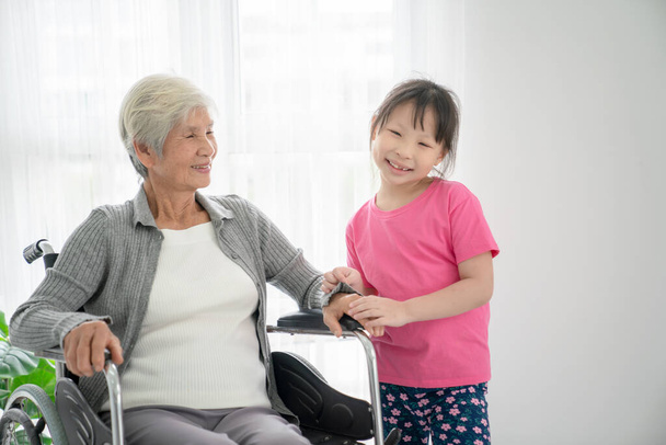 Ältere Patientin im Rollstuhl wartet mit Enkelkind im Krankenhaus - Foto, Bild