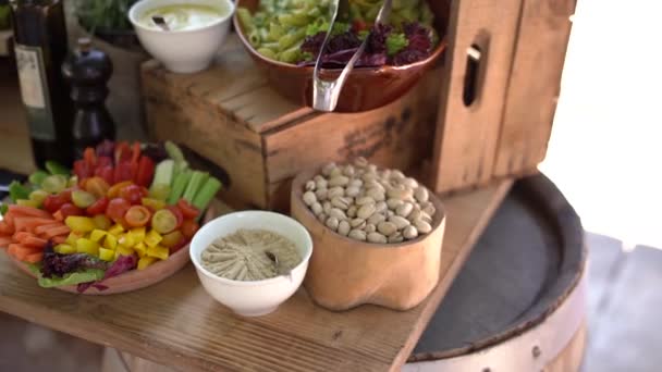 De buffettafel op de catering is een groot bord met pistachenoten, sauzen, salades en groentesnijwerk. - Video