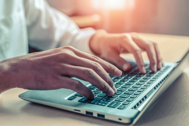 Homme d'affaires tapant à la main sur le clavier de l'ordinateur d'un ordinateur portable au bureau. Concept d'entreprise et de finance. - Photo, image