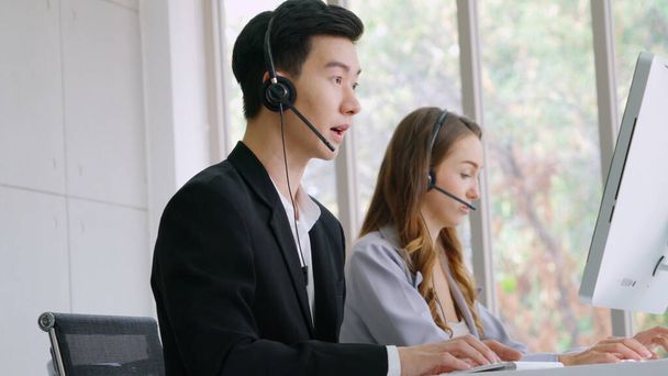 Vezetékes fülhallgatót viselő üzletemberek dolgoznak az irodában, hogy támogassák a távoli ügyfelet vagy kollégát. Call center, telemarketing, ügyfélszolgálati ügynök nyújt szolgáltatást telefonon video konferencia hívás. - Fotó, kép