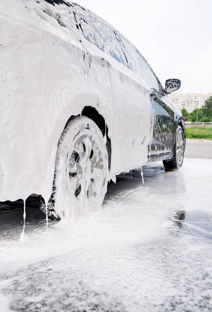 car on the side in the foam and bubbles from the detergent in the car wash - Φωτογραφία, εικόνα