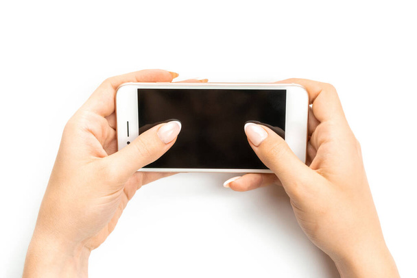 Γυναίκα με το τηλέφωνο. Γυναίκα κρατώντας smartphone στο θηλυκό χέρι με κενή κενή οθόνη που απομονώνεται σε λευκό φόντο. Κινητό τηλέφωνο με χώρο για κείμενο. Κινητή μάθηση - Φωτογραφία, εικόνα