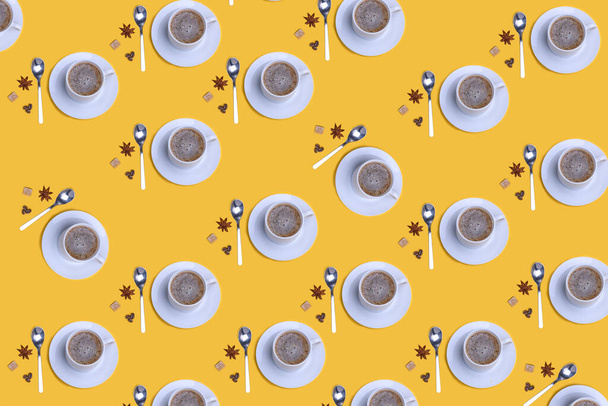 Het patroon van een kopje koffie, lepel, koffiebonen, suiker, anis op gele achtergrond - Foto, afbeelding
