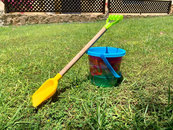 jouet en plastique seau et bêche sur une pelouse verte - Photo, image