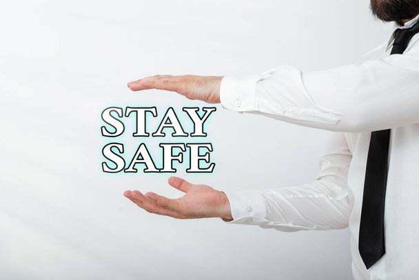 Word writing text Stay Safe. Business concept for secure from threat of danger, harm or place to keep articles Model with pointing hand finger symbolizing navigation progress growth. - Foto, afbeelding