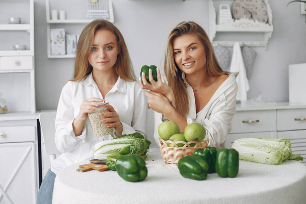 Mutfakta sebzeli güzel ve sportif kızlar. - Fotoğraf, Görsel