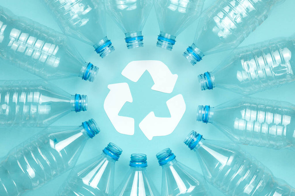 Imagem de cor horizontal com uma vista aérea de uma garrafa de plástico transparente sem tampas em um fundo azul. Conceito de reciclagem e ambiente
. - Foto, Imagem