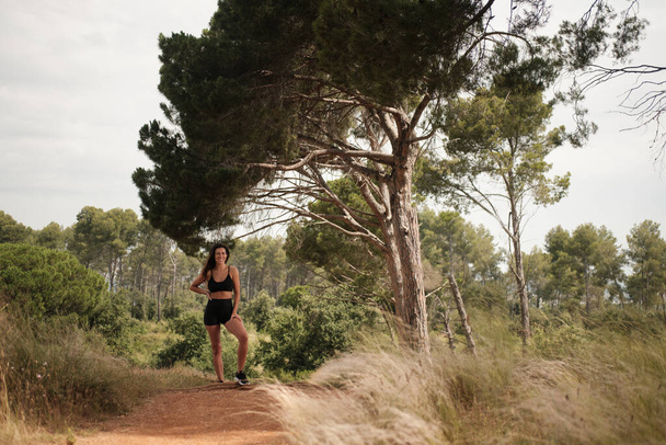 athletic brunette girl posing in a forest - Foto, Imagem