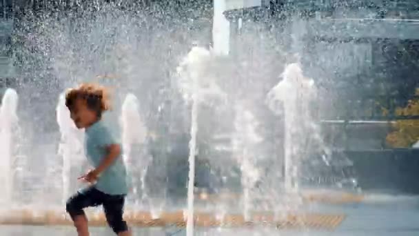Ευτυχισμένο παιδί διασκεδάζει κοντά στο σιντριβάνι - Πλάνα, βίντεο