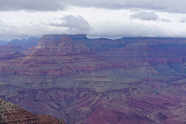Grand Canyon National Park, Αριζόνα: Το φιμέ μοβ, κόκκινο και καφέ χρώματα του Grand Canyon κάτω από ένα χαμηλό σύννεφο κάλυψης, δει από την περιοχή Desert View του South Rim. - Φωτογραφία, εικόνα