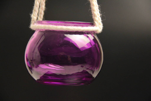 Kerzenständer aus lila Glas hängen am Seil - Foto, Bild