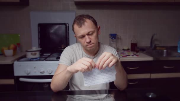 Dühös ember könnyek papír kis darab, ül este a konyhában - Felvétel, videó