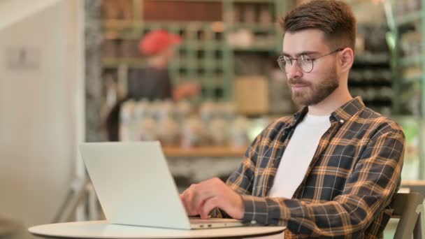Junger Mann benutzt Laptop im Café  - Filmmaterial, Video