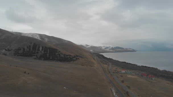 kylmä iso järvi lumisten vuorten välissä - Materiaali, video