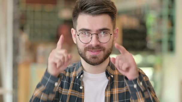 Portret van een jonge man wijzend vinger en uitnodigend  - Video
